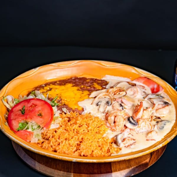 El Mirador 2's Mexican dish with shrimp, mushrooms, rice, beans, lettuce, and tomato in a creamy sauce.