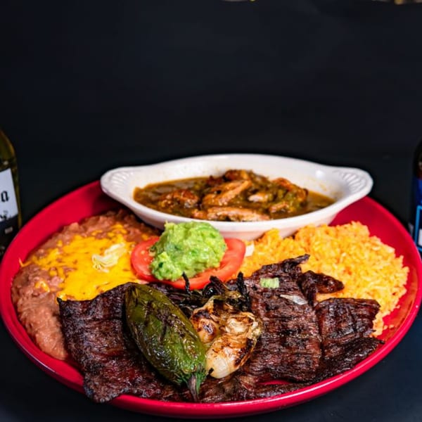 El Mirador 2's Mexican dish with grilled meat, rice, beans, guacamole, and a side of stew.
